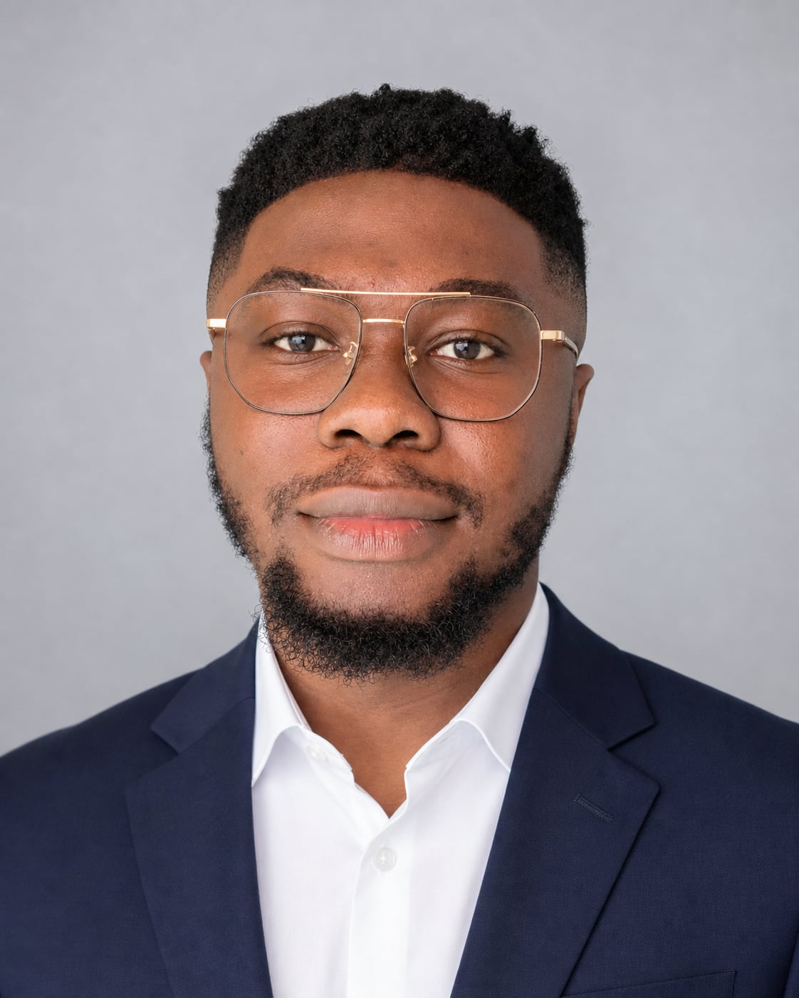 Portrait of Omogbolahan Adekanye, CEO of ÀMÓJÚTÓ, wearing glasses and a navy suit.